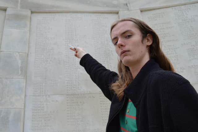 Leeds student Joseph Doyle points out the name of Private Sam Stirk after laying a cross at Tyne Cot Cemetery, Belgium. Picture by Zoe Polydorou/ Equity.