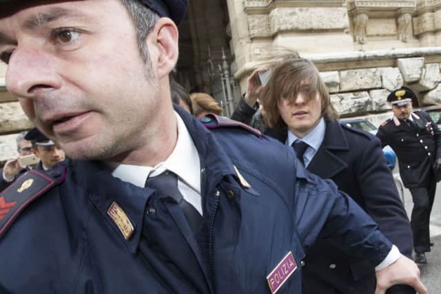 Raffaele Sollecito, right, leaves Italy's highest court building, in Rome