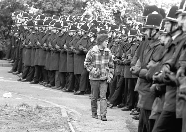 A picket walks in front of police lines at Orgreave