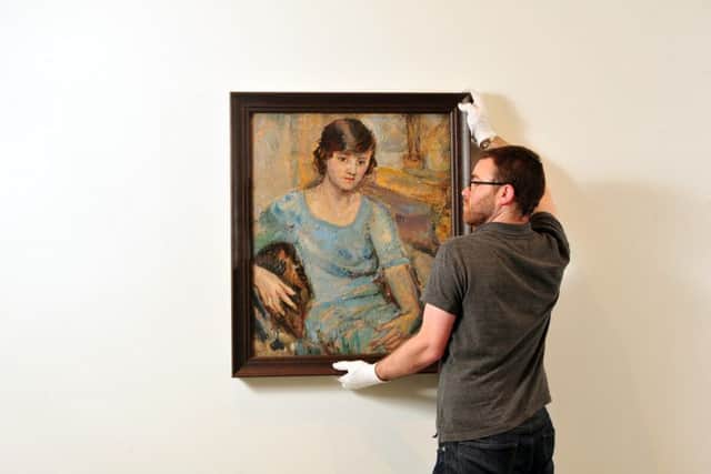 The Hepworth Gallery technician Matt Jamieson hangs a rare portrait of the young Barbara Hepworth.
Picture by Tony Johnson