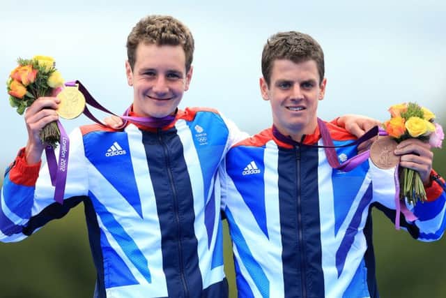Alistair Brownlee and Jonny Brownlee (right) celebrate their Olympic medals.