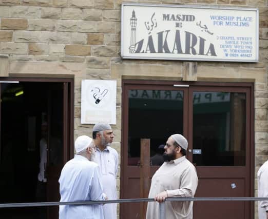 Men outside the Masjid E Zakaria Mosque, in Dewsbury, where Talha Asmal, Britain's youngest suicide bomber attended