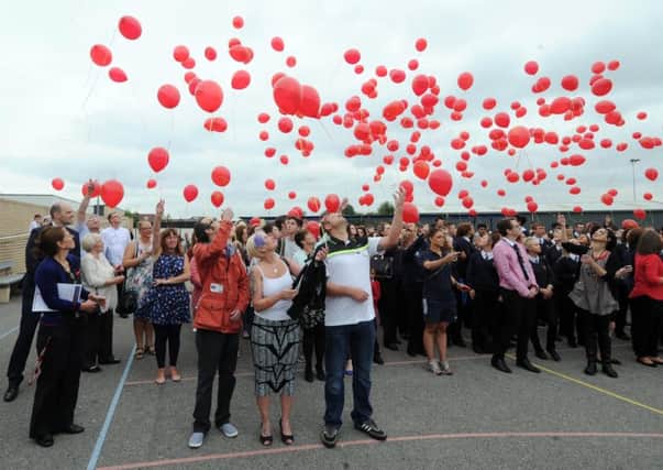 Tracy and Alex Asquith, the parents of Kyle Asquith, are pictured with Raymond Tait as 1,200 balloons are released at Cockburn School, in Beeston. Picture by Simon Hulme.