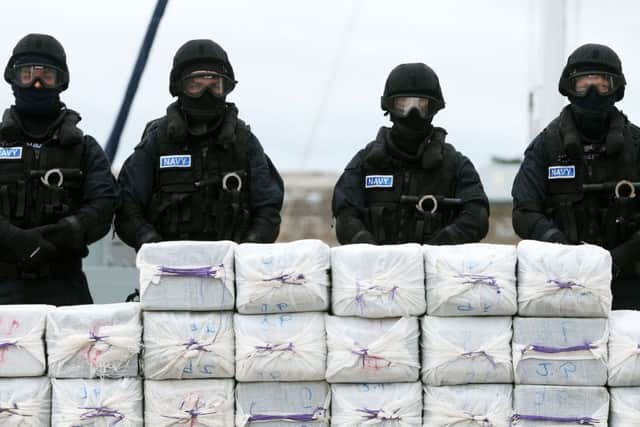Members of the navy stand behind what is believed to be cocaine