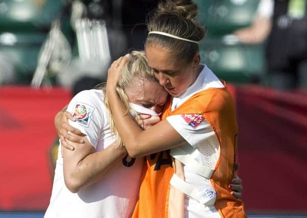 England's Josanne Potter, right, consoles Laura Bassett after defeat to Japan