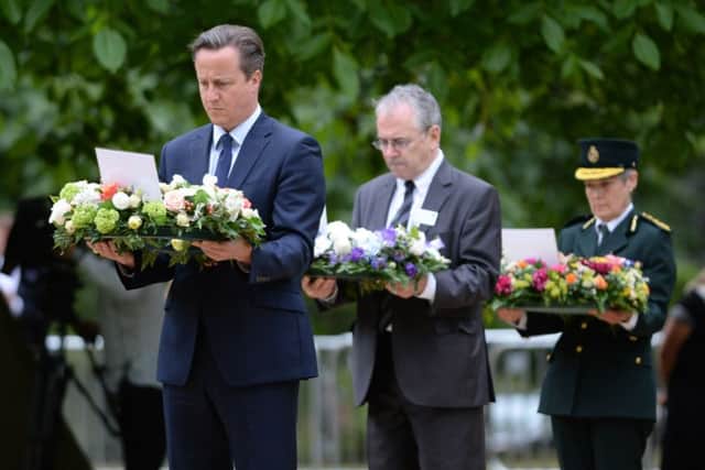 David Cameron, Transport Commissioner Sir Peter Hendy and Dr Fiona Moore, Chief Executive of London Ambulance, carry wreathes at the July 7 memorial in Hyde Park, London, as Britain remembers the July 7 attacks amid a welter of warnings about the enduring and changing threat from terrorism a decade on.
