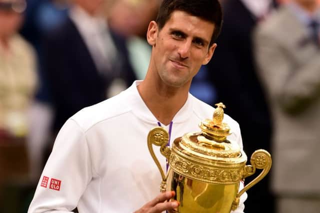 Novak Djokovics satisfaction is obvious as he clutches the mens singles trophy at Wimbledon for the third time after beating Roger Federer for the second year running (Picture: Dominic Lipinski/PA).