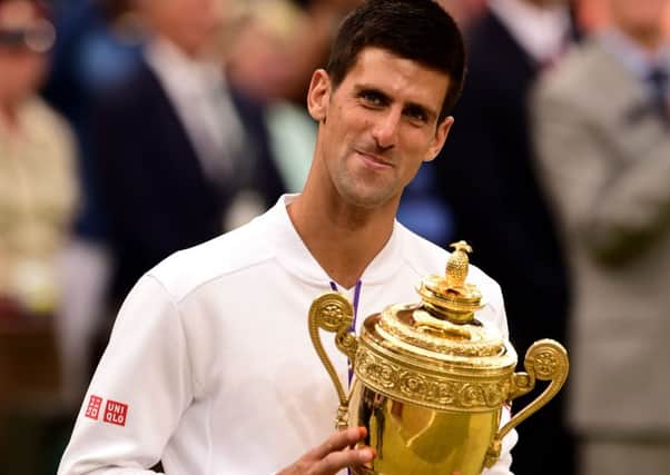Novak Djokovics satisfaction is obvious as he clutches the mens singles trophy at Wimbledon for the third time after beating Roger Federer for the second year running (Picture: Dominic Lipinski/PA).