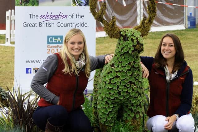 Charley Thomas (left) and Lucy Jenkins from the Country Land and Business Association with a stag made from foliage at the CLA Game Fair at Harewood House. (Gl1006/66k)