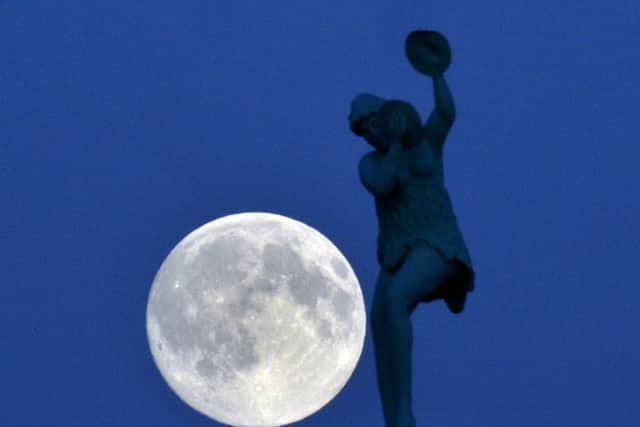 The moon rises over a statue on the Whitley Bay Dome, as the UK experiences its first 'blue moon' since 2012.