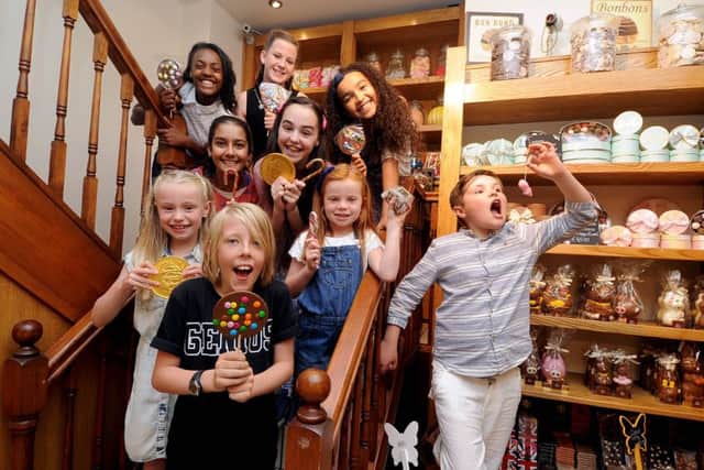 Members of the young cast of the West Yorkshire Playhouses Christmas show, Chitty Chitty Bang Bang visiting sweet shop Bon Bons, Thornton Arcade, Leeds.