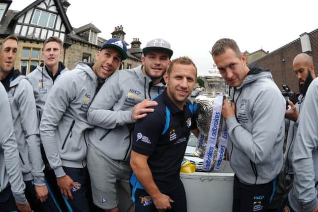 Leeds Rhino's players  on the back of the open top bus on their celebratory journey.