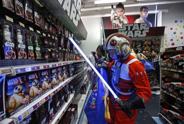 A fan dressed as a Star Wars character shops at a toy store at midnight in Hong Kong