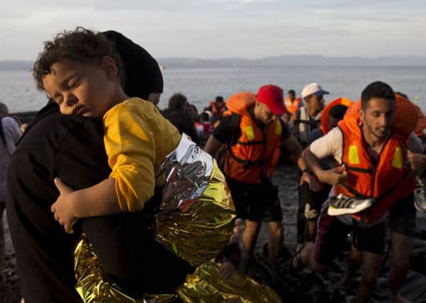 Syrian refugees arrive on a dinghy after crossing from Turkey to Lesbos.