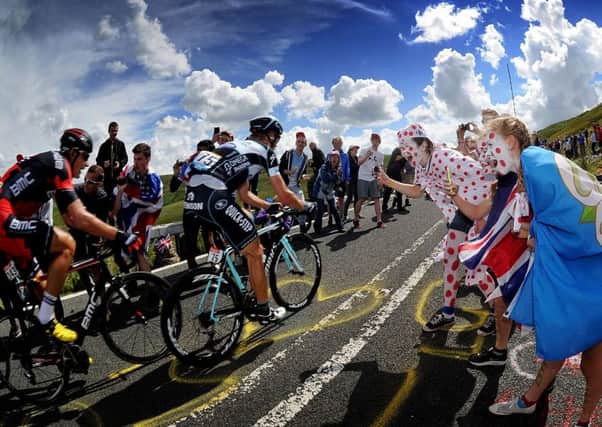 Fans cheering on cyclists as they tackle the Holme Moss climb on the Tour de France Stage 2 in July 2014.