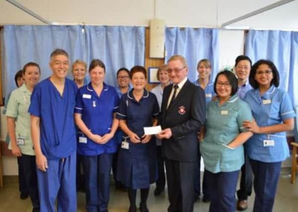 Drax GC Seniors' captain John Leonard passes over the proceeds of his Charity Day to staff at St James's Hospital, Leeds.