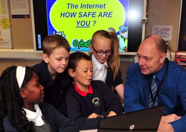 20 October 2015 .......  Richard Thornton, crime reduction officer with West Yorkshire Police's new cyber-crime unit gives lessons to Year 5 pupils Ruth Oikelome, Josh Gudgeon, Aaron Martin and Mia Eddison at Stanningley Primary School  about topics such as on line bullying and safe use of social media.  Picture Tony Johnson