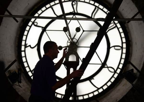 Premises manager Nick Tyas makes an adjustment to the Wakefield Town Hall clock as Daylight Saving Time ends at 2am on Sunday 25 October. Picture: Scott Merrylees