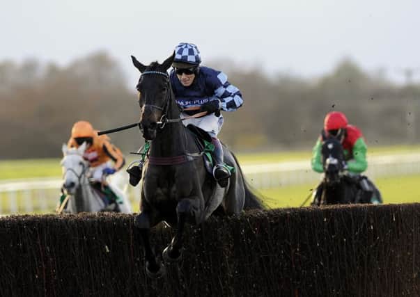 Menorah and Richard Johnson jump the last fence as they go on and win the bet365 Charlie Hall Chase