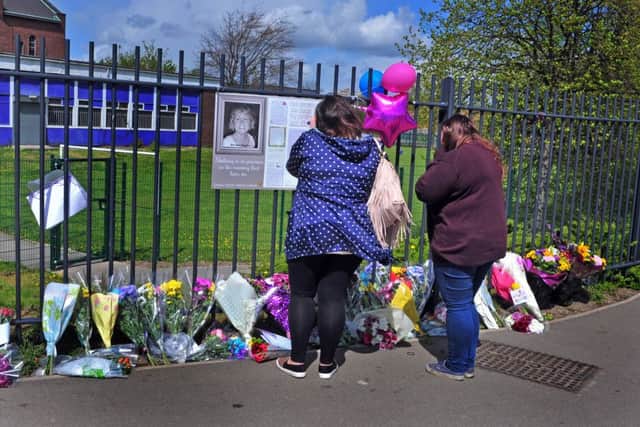 Mourners  looking at the floral tributes outside Corpus Christi Cathlolic College earlier this year to mark a year since teacher Ann Maguire's murder. Picture: Tony Johnson.
