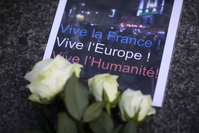 A poster and flowers to mourn for the victims killed in the Friday's attacks in Paris.