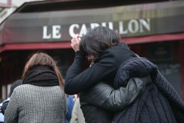 People console each other outside Le Carillon bar, Paris
