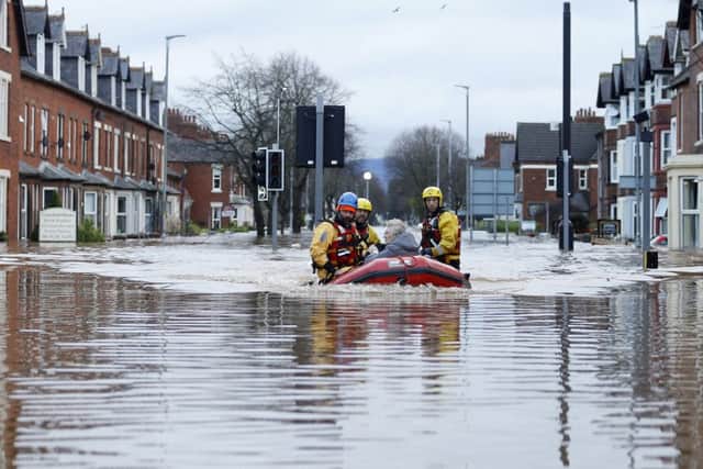Emergency workers use a boat in floodwater on Warwick Road in Carlisle. Owen Humphreys/PA Wire