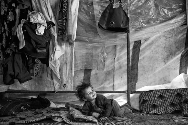 A Syrian boy waking up inside his family's tent in the Bekaa Valley, Lebanon, in a camp similar to the one Imad and his family stayed in for three years.