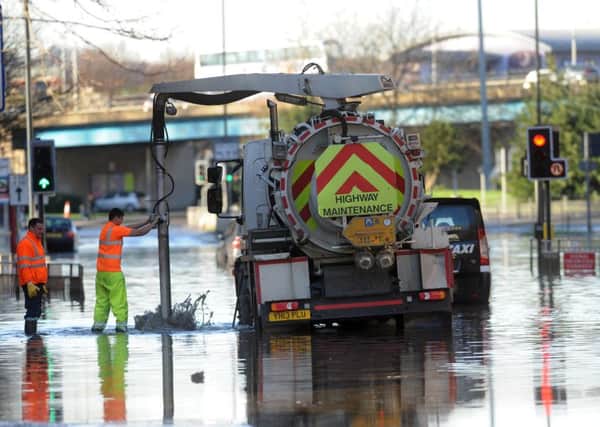 Workmen clear the drains on Wellington Street, Leeds which was flooded
