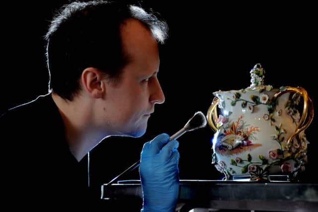 Adam Toole, curator, in the Library Room cleaning a Rockingham Potpourri case and lid.