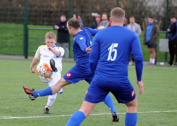 Conor Firth, of Gildersome Spurs, gets a shot away against Morley Town AFC Reserves. PIC: Steve Riding