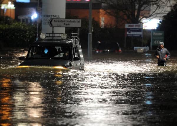 BOXING DAY 2015: A car and a pedestrian make their way  through floodwater on Kirkstall Road. PICS: Tony Johnson