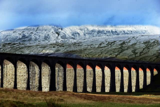 Sunlight lights up the arches on the Ribblehead Viaduct as a backdrop of snow covers the hills of Blea Moor. Picture: Gary Longbottom