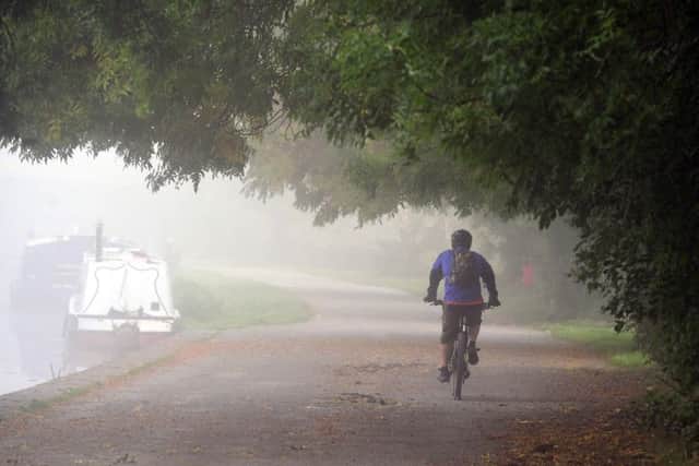 2 October 2015.......   A mountain biker makes his way through the fog on the towpath on the Leeds Liverpool Canal at Rodley. Picture Tony Johnson