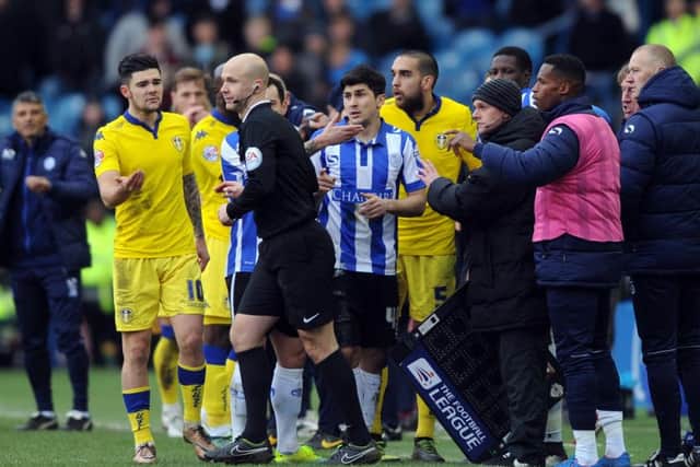 Referee Anthony Taylor is surrounded by Leeds United players after he disallowed Liam Cooper's goal.