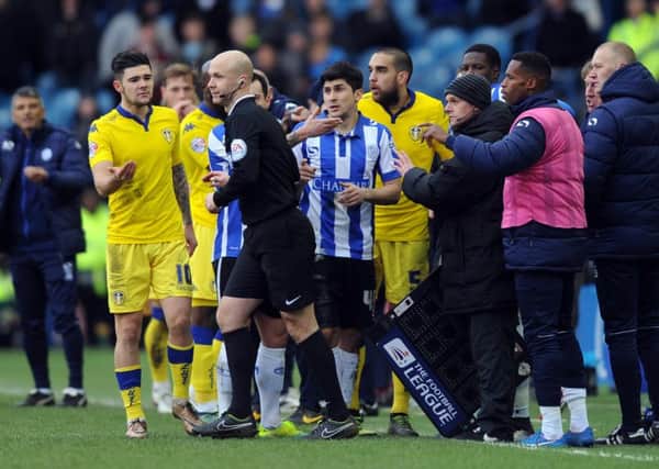 Referee Anthony Taylor is surrounded by Leeds United players after he disallowed Liam Cooper's goal.
