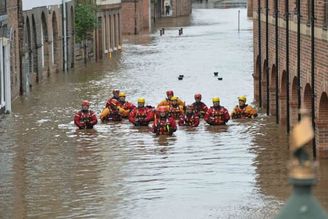 Members of the Mountain Rescue teams wade through floodwater in Skeldergate, York, on December 28