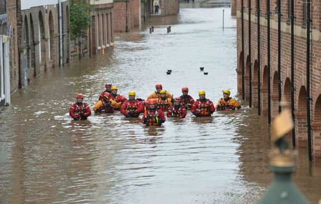 Members of the Mountain Rescue teams wade through floodwater in Skeldergate, York, on December 28
