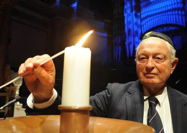 Rudi Leavor lights a memorial candle.