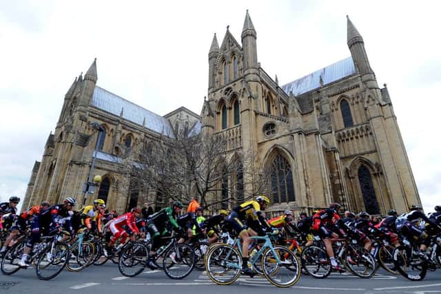 Riders in the main peloton pass Beverley Minster in the Tour de Yorkshire. (Picture: James Hardisty)