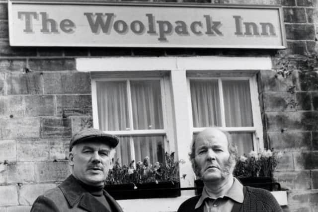 Emmerdale characters Mr Wilks (Arthur Pentelow) and Amos Brearley (Ronald Magill) standing outside the Woolpack Inn.
