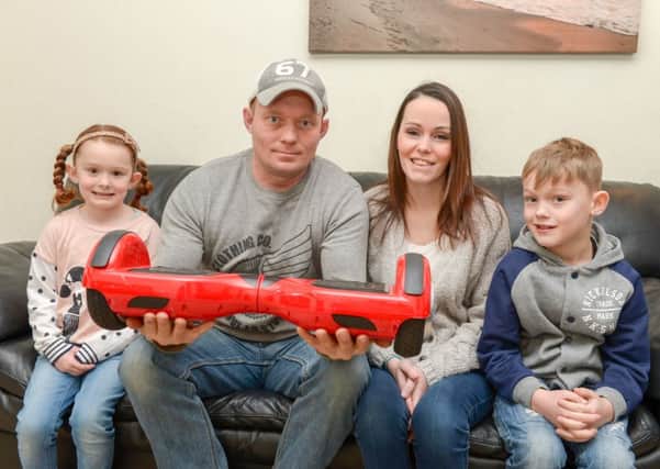 Mark Tomlin with his partner Angela Taylor and their children Millie-Mea and Max. See SWNS story SWHOVER; A dad has suffered amnesia after he was thrown to the ground - by a faulty HOVERBOARD. Father-of-four Mark Tamlin, 39, was looking forward to spending the Christmas with his family and gave his oldest son a new hands free "swegway" device. But when 12-year-old Owen Daniel opened the smart balance wheel - one of the must-have gifts of the year - he found it didn't work properly. Mark, of Chessington, Surrey, gave it a go himself and ended up hitting his head and suffered concussion - and now can't remember Christmas.