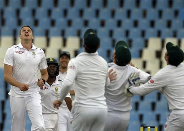 South Africas Morne Morkel, left, celebrates with teammates after dismissing Englands captain Alastair Cook on day four at Centurion. Picture: AP/Themba Hadebe.