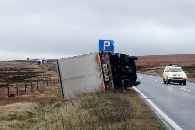 A lorry blown over by high winds on the A628 Woodhead Pass, in South Yorkshire, as swathes of the county are braced for a deluge of rain which could pour more misery on communities still reeling from flooding after Christmas.
