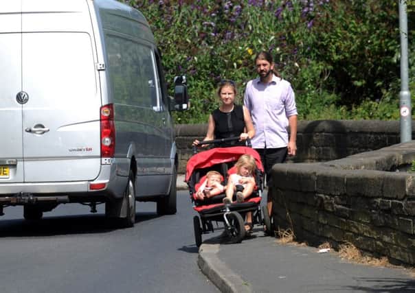 John and Anita Dorsett with there children Aidan aged 10 months and Erin aged 3, struggle to get through on the narrow footpaths at Wyther Lane, Leeds.SH1001647a...21st July 2014 Picture by Simon Hulme