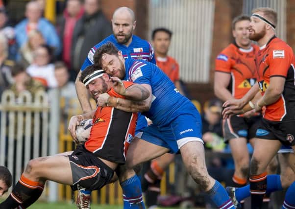 Castleford's Lee Jewitt is tackled by Wakefield's Chris Annakin and Danny Kirmond.