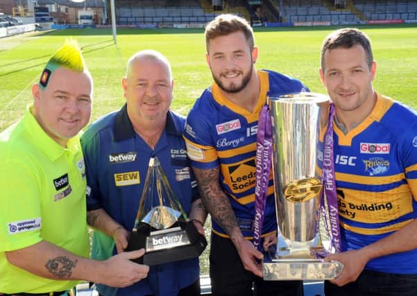 Darts players Peter Wright and Robert Thornton with the Premier League Darts trophy and Zak Hardaker and Danny McGuire with the Super League trophy both of which kick off in Leeds tonight.