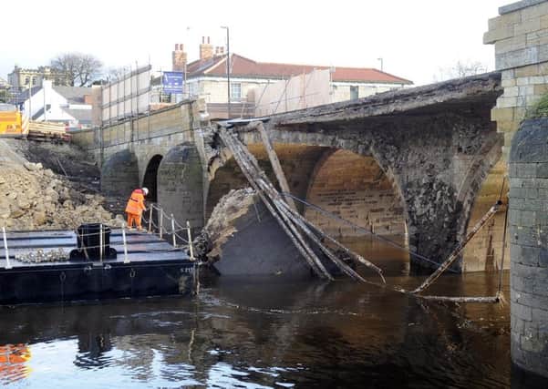 The floating pontoon is been moved into position to help rebuild the 300 year old Tadcaster bridge that was damaged by the recent flooding over the Christmas period. PIC: James Hardisty