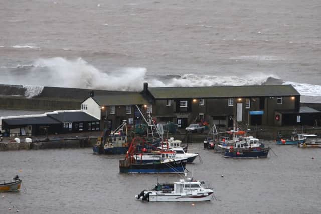Waves crash against the harbour wall in Lyme Regis, Dorset as winds of nearly 100mph battered Britain