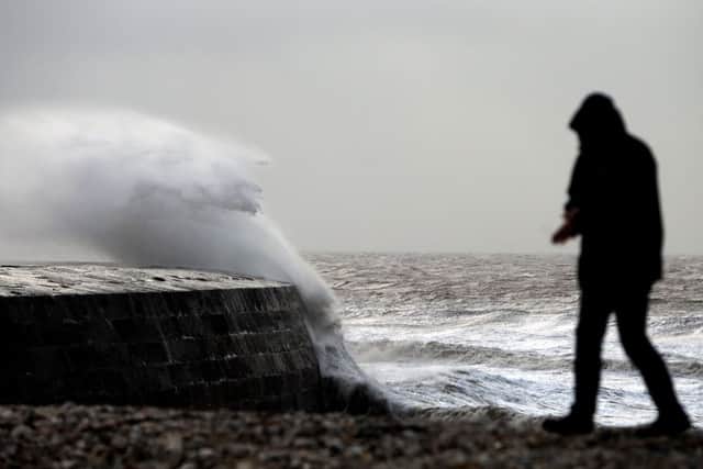 Waves crash against the harbour wall in Lyme Regis, Dorset